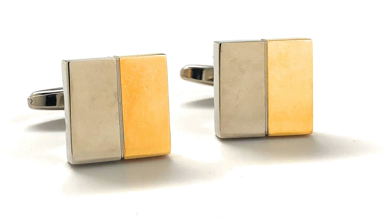 Two gold and silver rectangular cufflinks on a white background