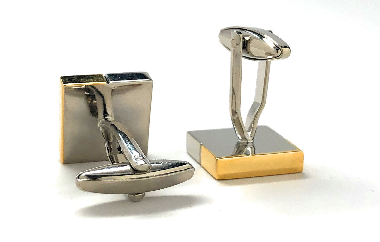 Gold and silver cufflinks on a white background