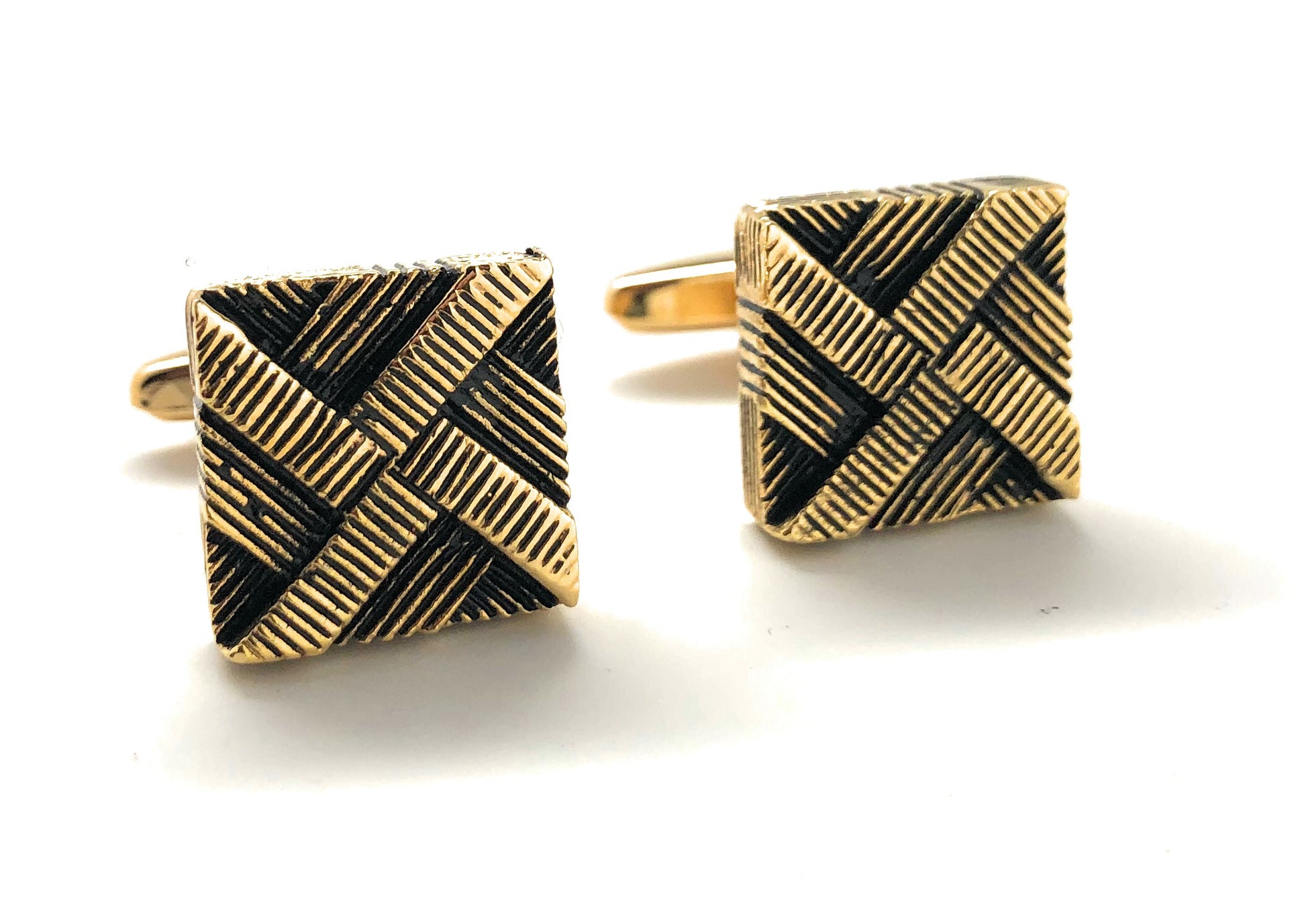 Gold and black patterned square cufflinks on a white background