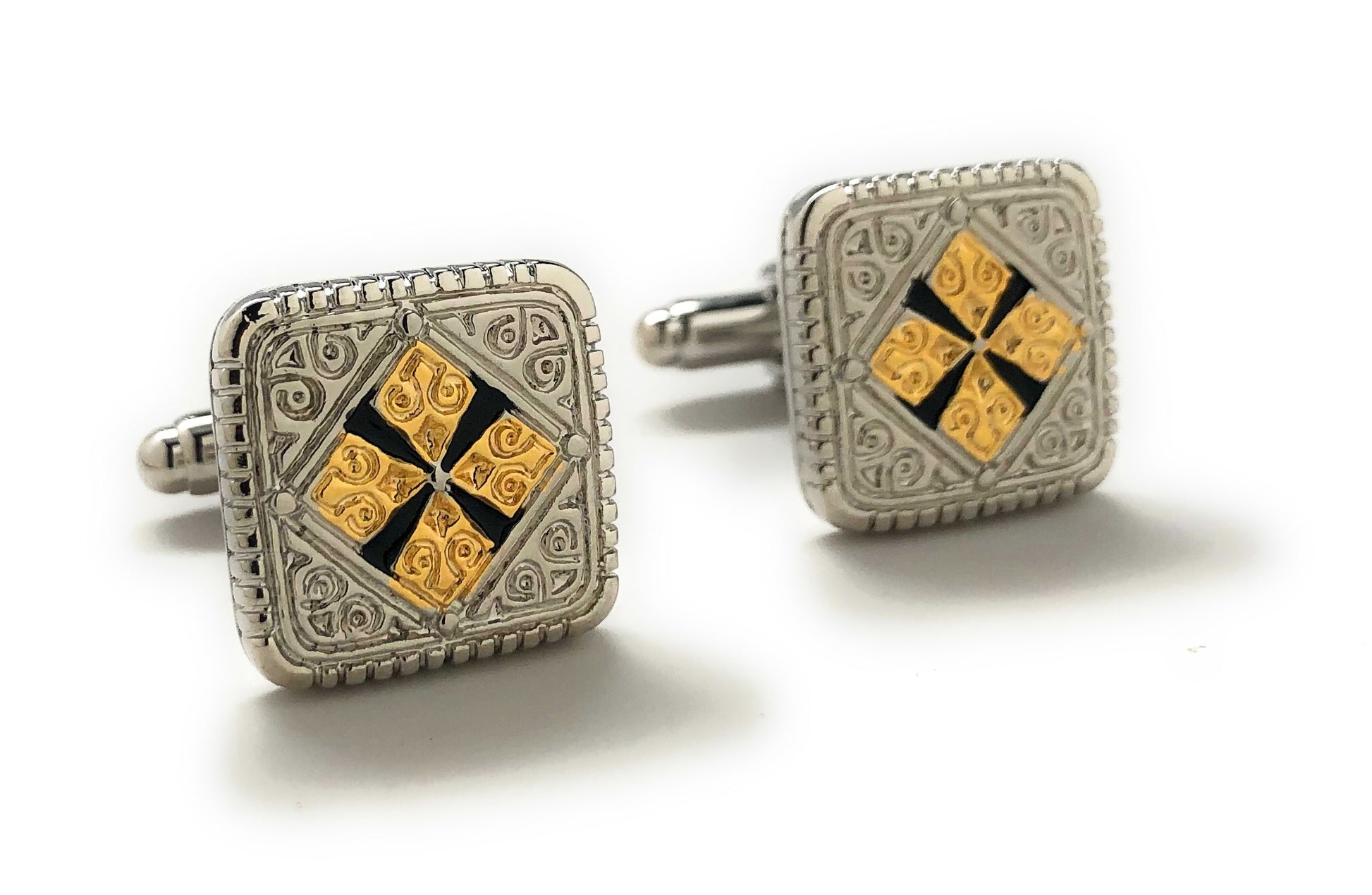 Pair of square cufflinks with gold and black design on a white background