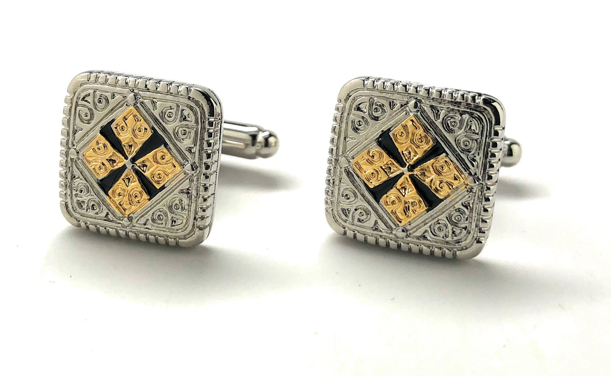Pair of square cufflinks with gold and black design on a white background
