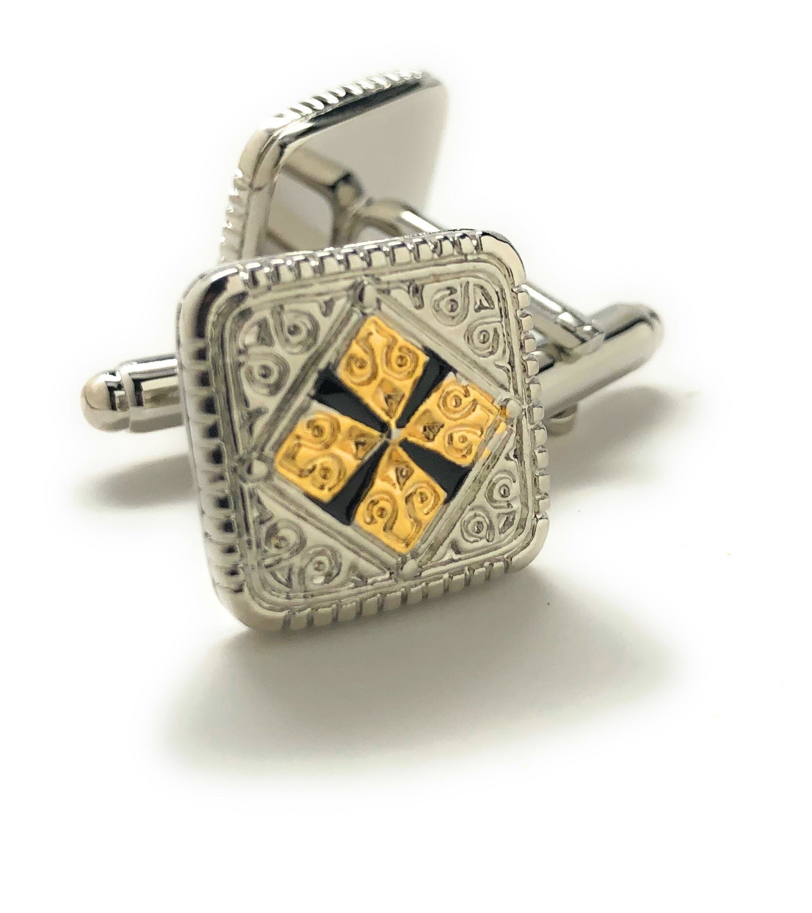 Silver cufflink with gold and black design on a white background