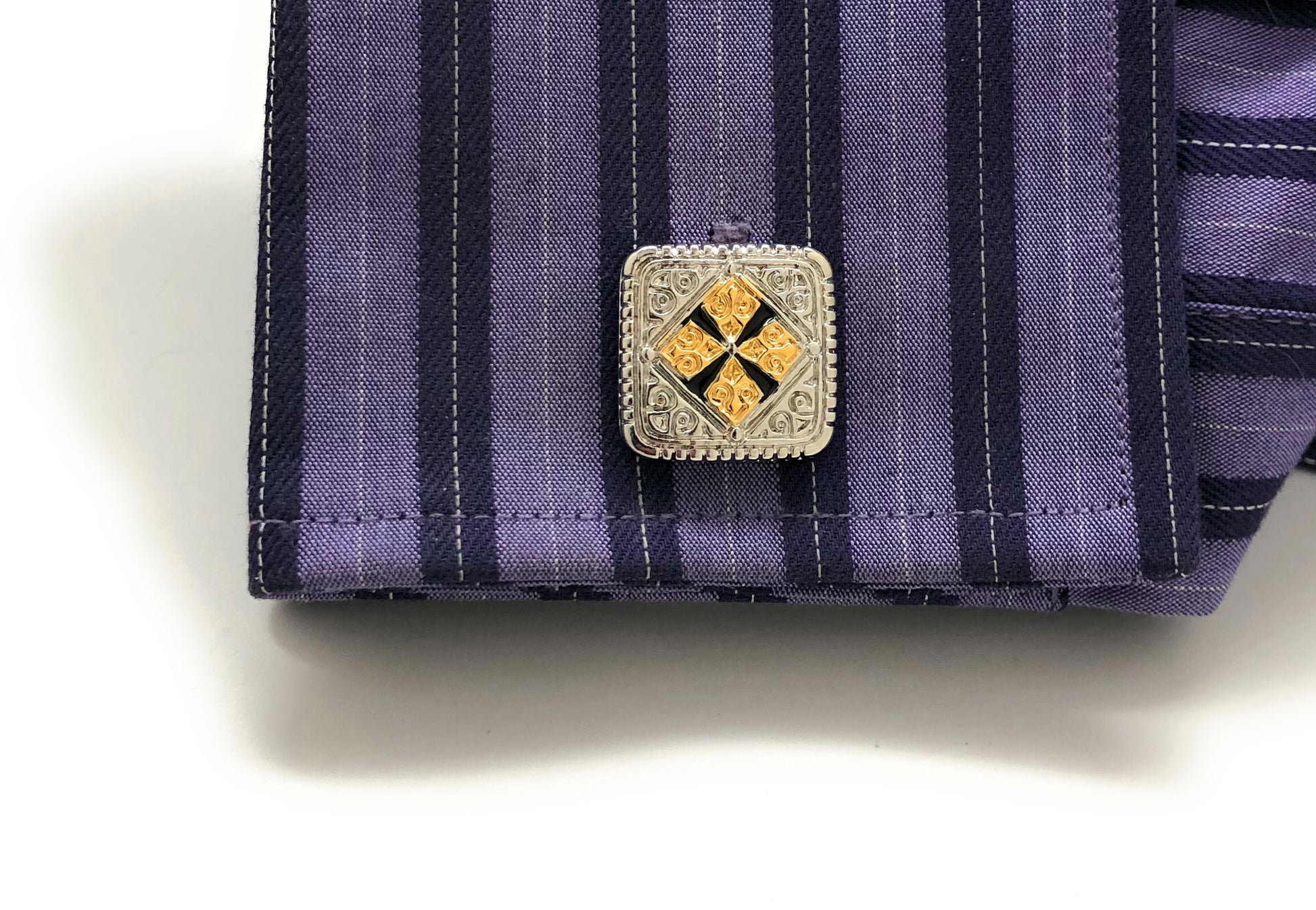 Close-up of a purple striped shirt with a decorative cufflink on a white background