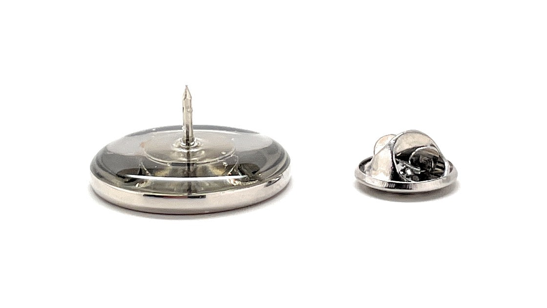 Metallic badge with a central pin on a white background