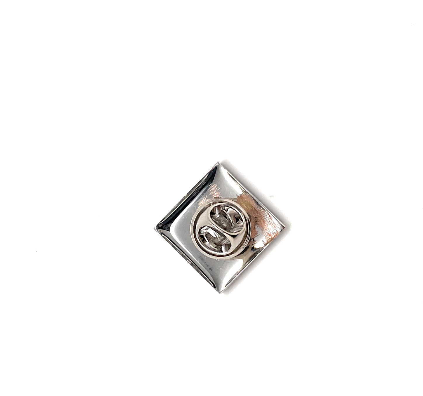 Silver square-shaped object with a circular design on a white background