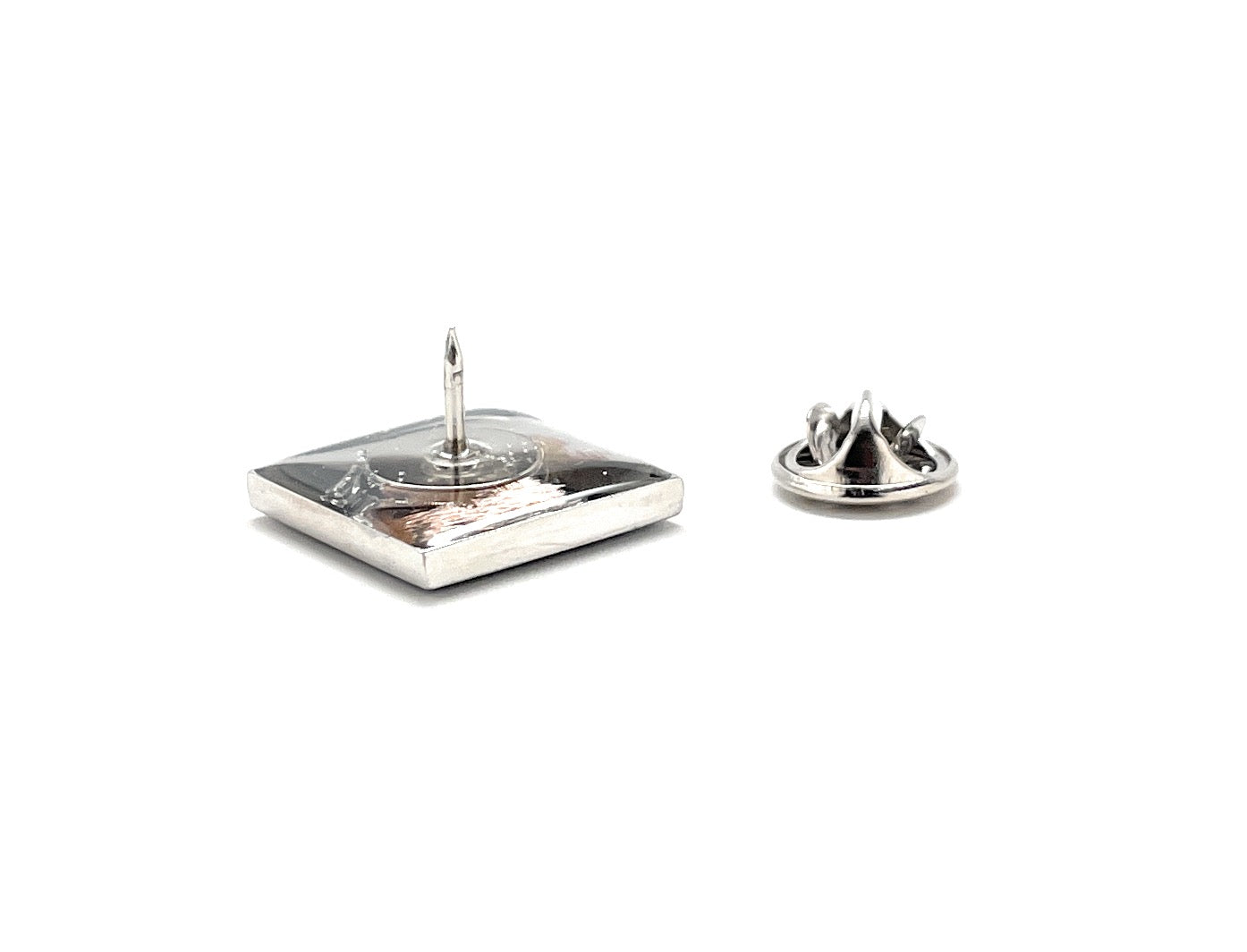 Silver lapel pin with a decorative design on a white background
