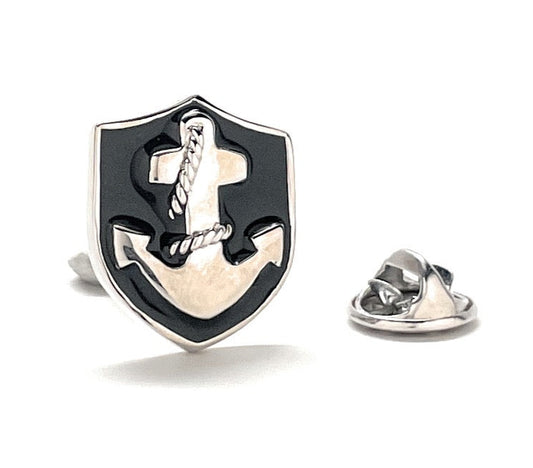 Shield-shaped pin with cross design on a white background