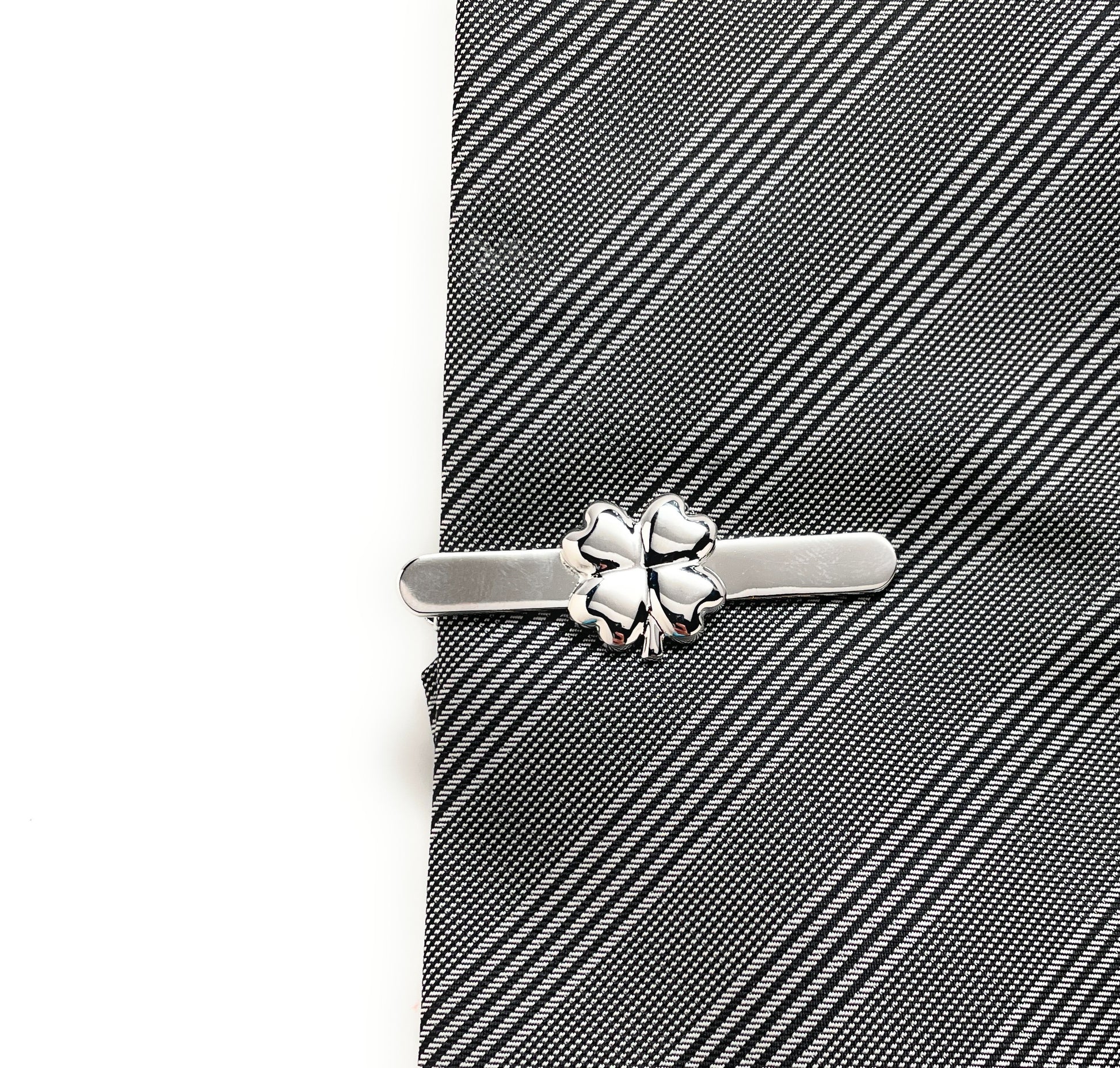 Silver tie clip on a gray striped tie