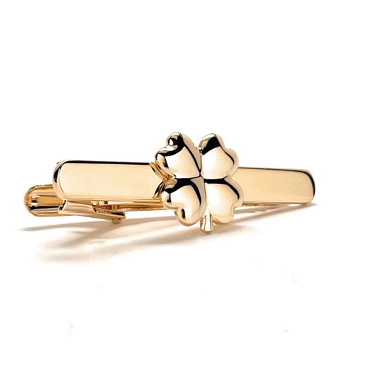 Gold tie clip with a dog design on a white background