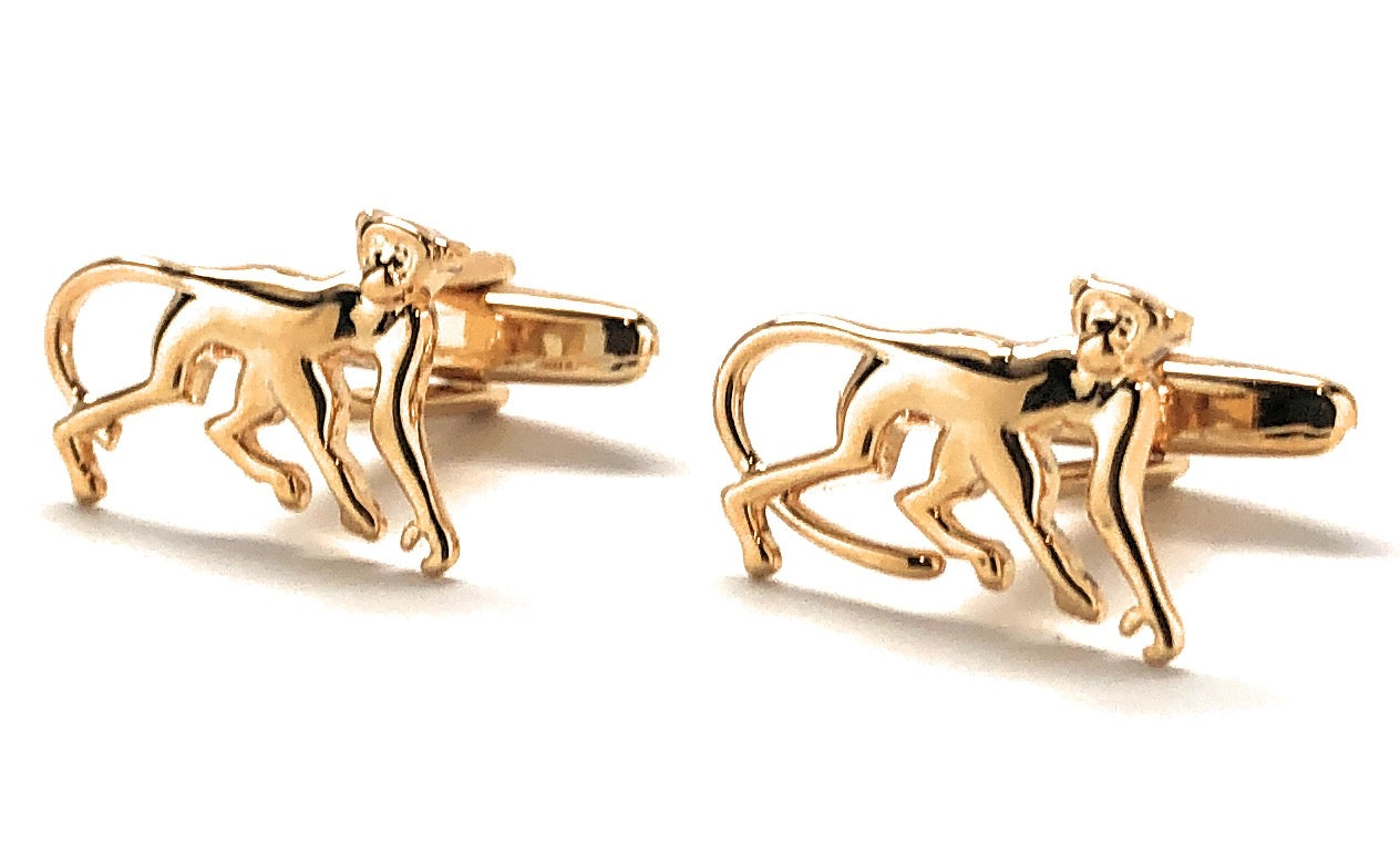 Gold monkey cufflinks on a white background