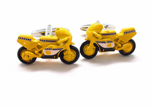 Yellow motorcycle-shaped cufflinks on a white background