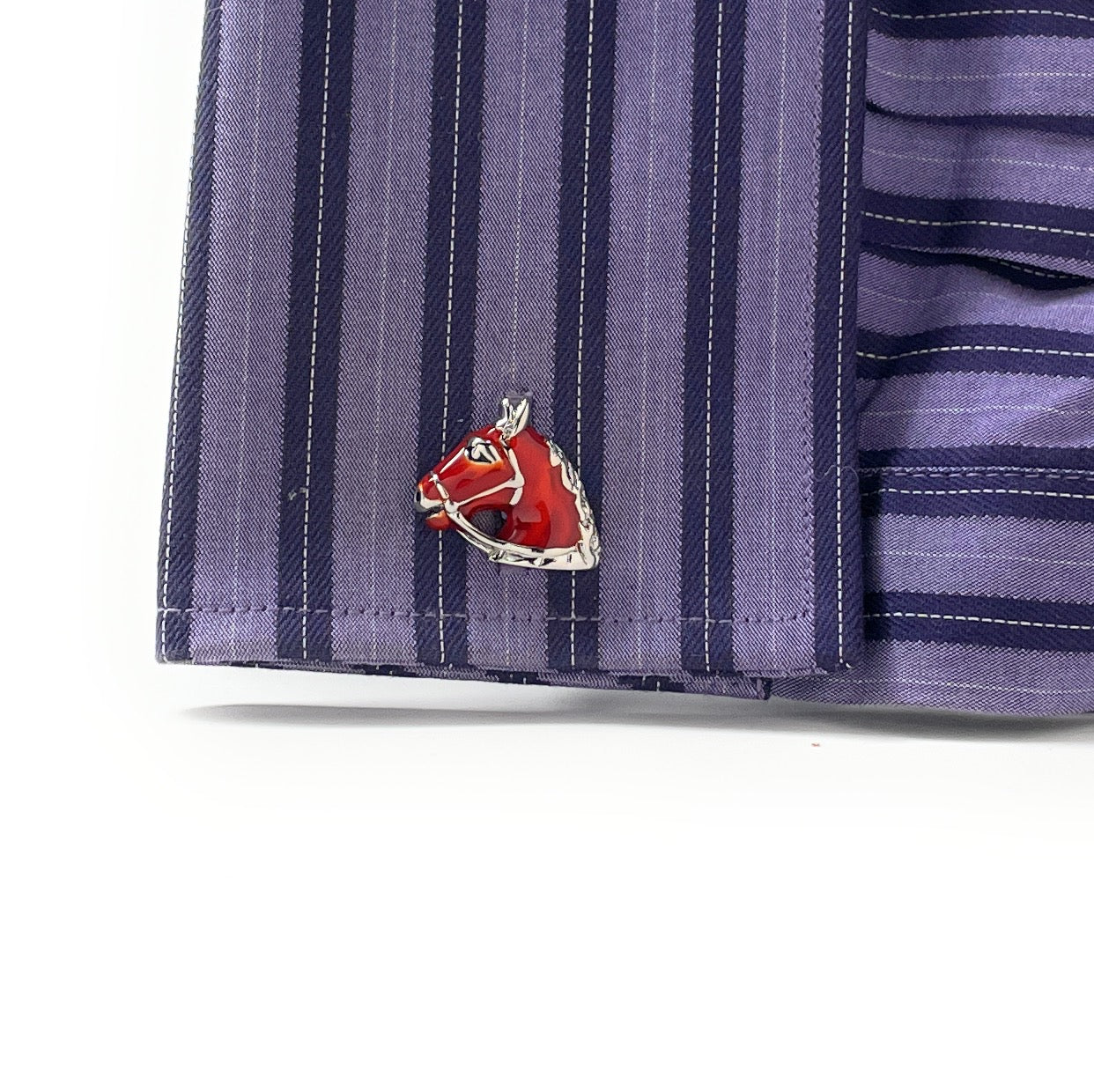 Close-up of a purple striped shirt with a red horse emblem on a white background