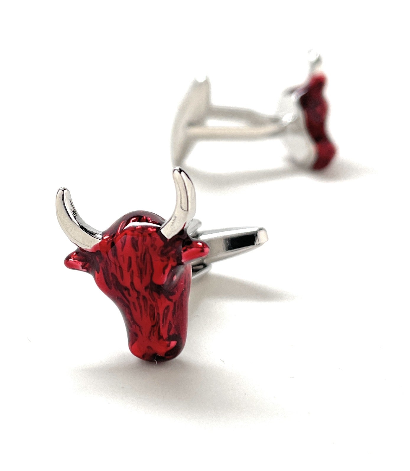 Red bull head cufflinks with silver accents on a white background