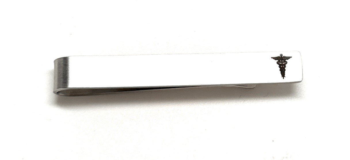 Metallic tie clip with a caduceus symbol on a white background