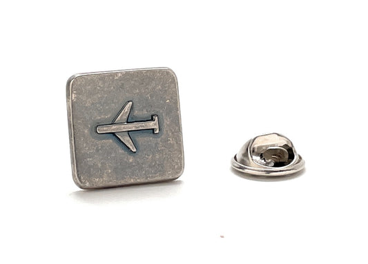Silver airplane-shaped lapel pin on a white background