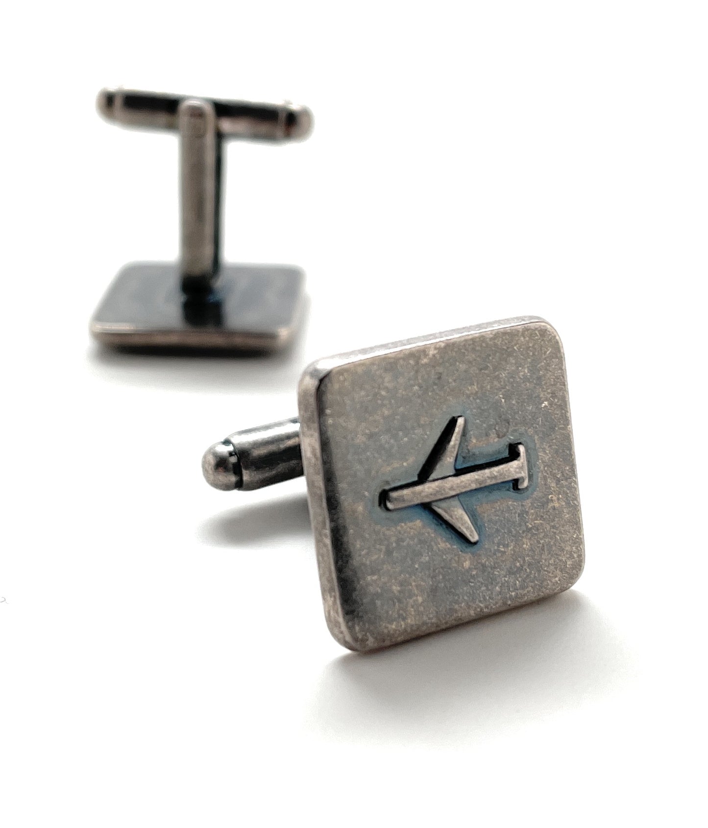 Silver airplane cufflinks on a white background