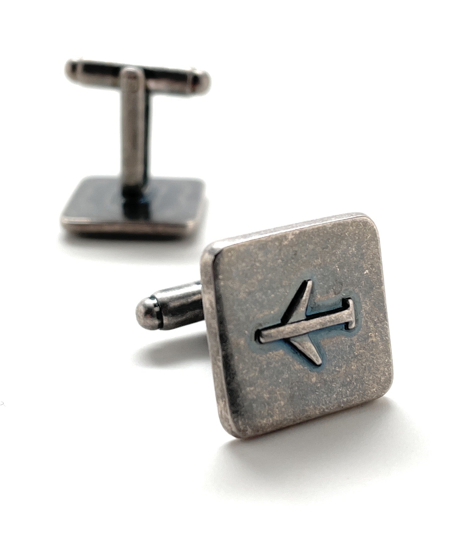 Silver airplane cufflinks on a white background