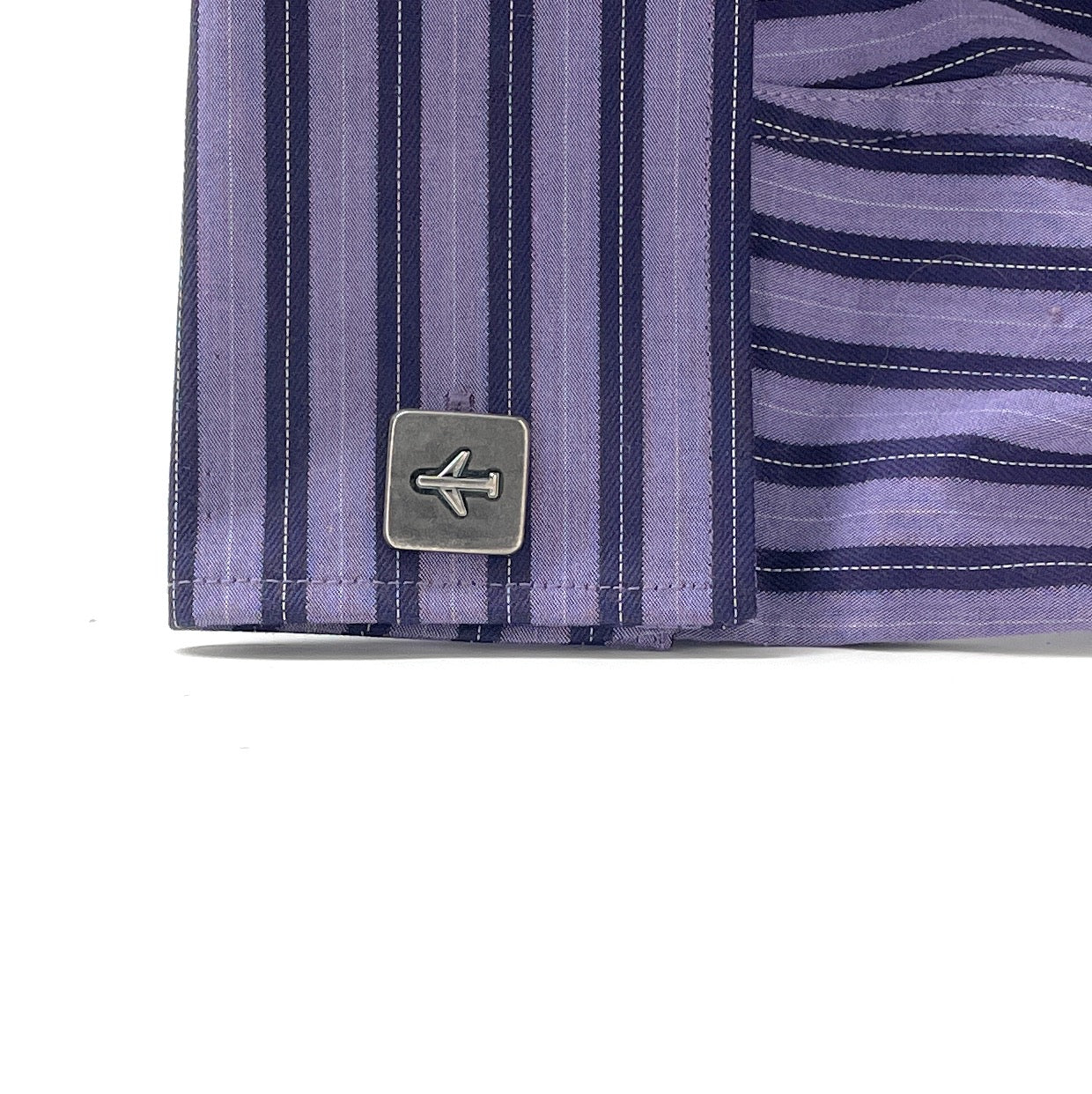 Close-up of a purple striped shirt with a brand logo on a white background