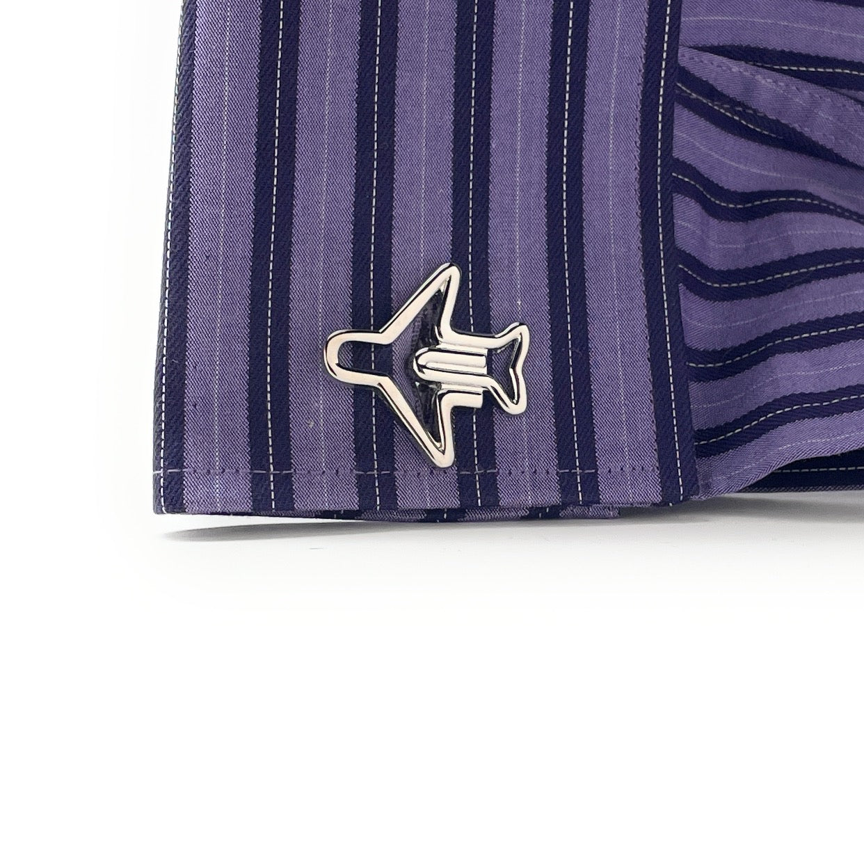 Close-up of a purple striped shirt with a fish-shaped button on a white background