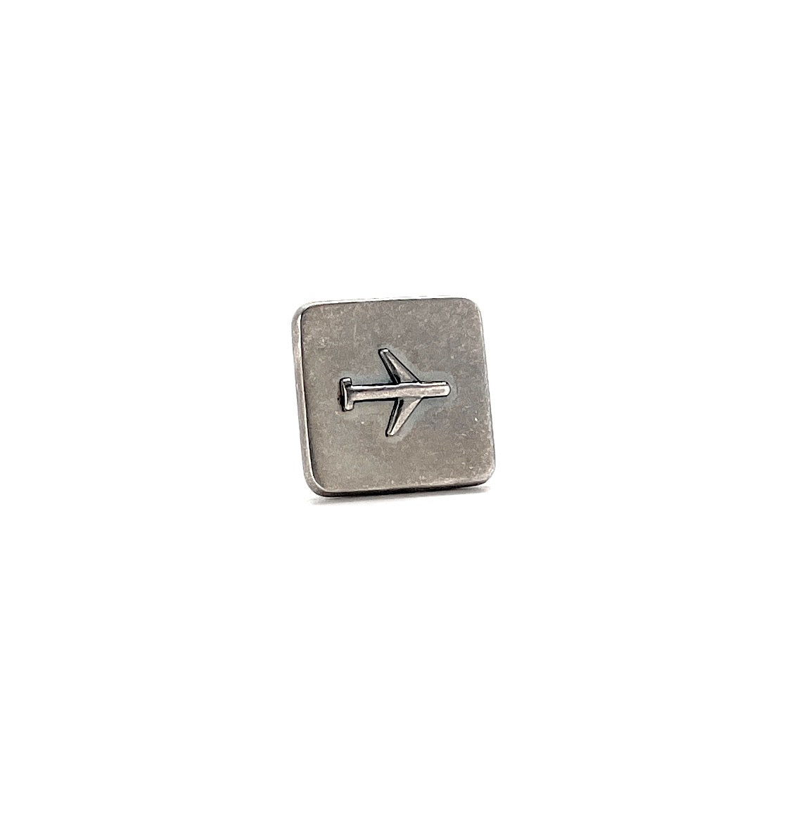 Silver square charm with airplane symbol on a white background