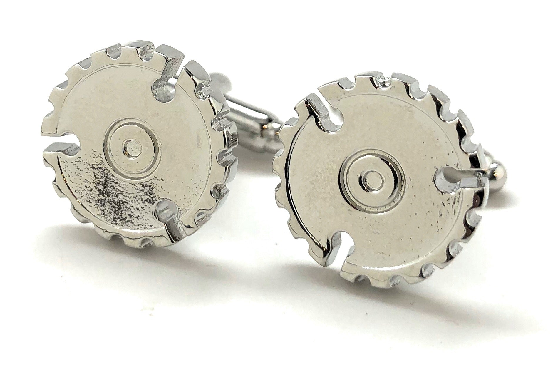 Silver circular saw blade cufflinks on a white background