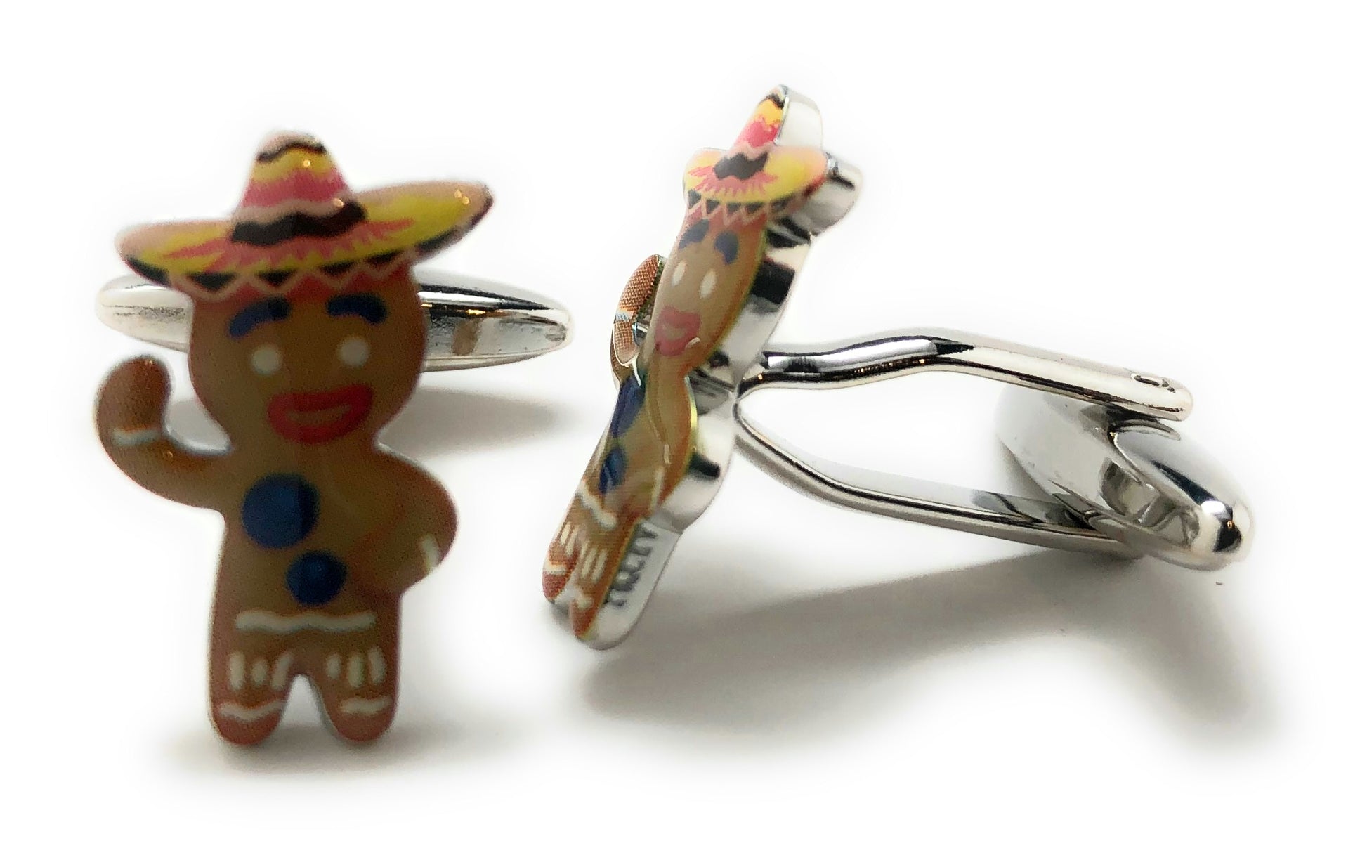 Gingerbread man cufflinks with colorful hats on a white background