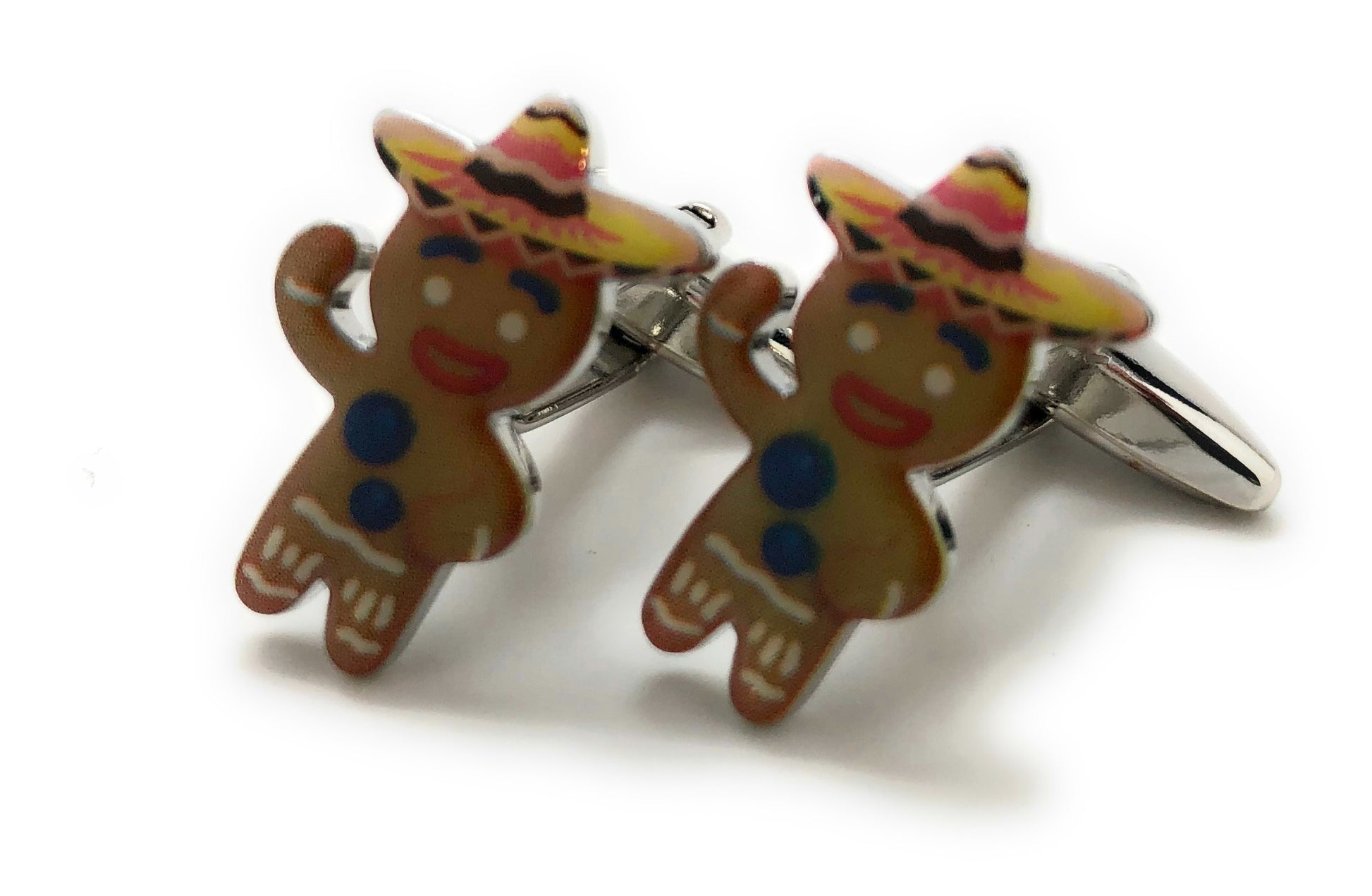 Gingerbread man cufflinks with colorful hats on a white background