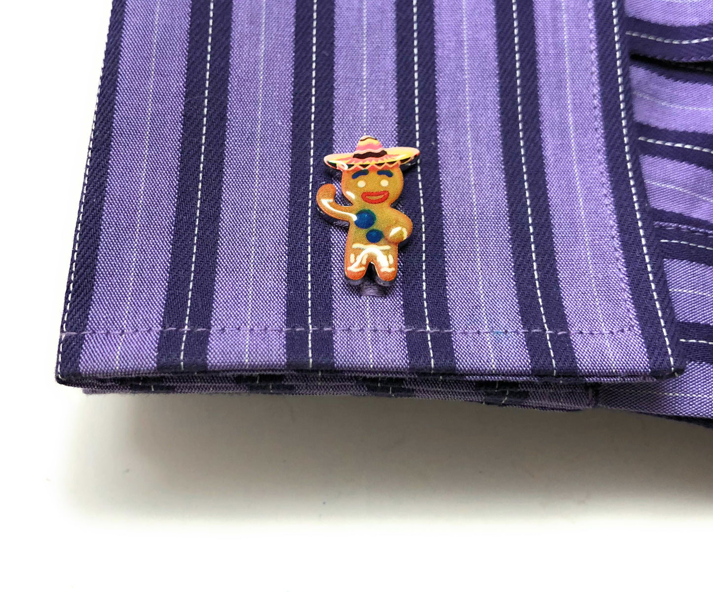 Colorful cartoon character pin on a purple striped fabric background