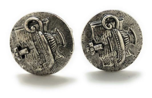 Pair of silver cufflinks with intricate design on a white background