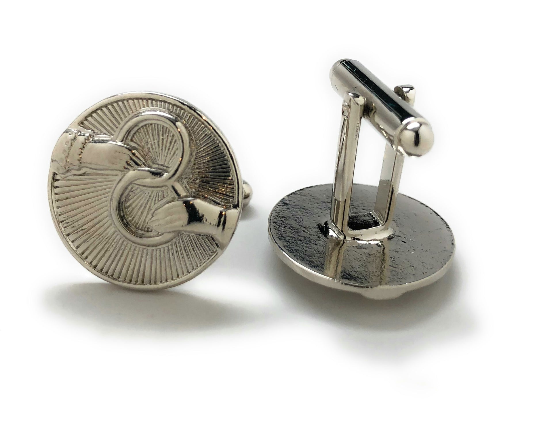 Silver cufflinks with intricate design on a white background