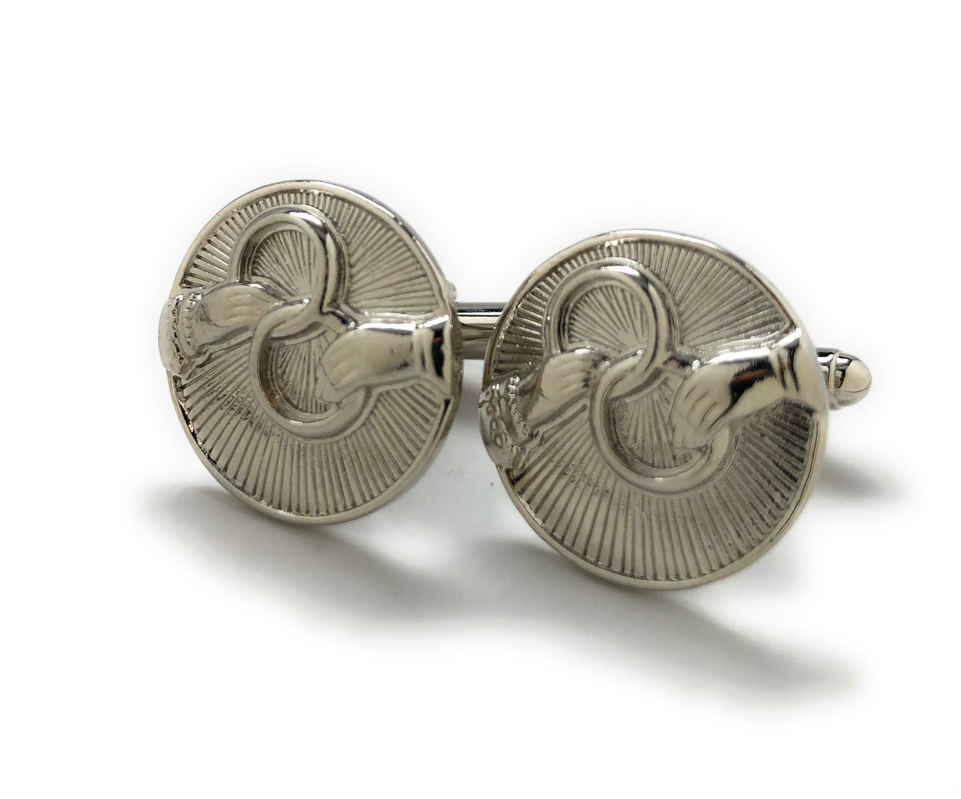 Silver cufflinks with intricate design on a white background