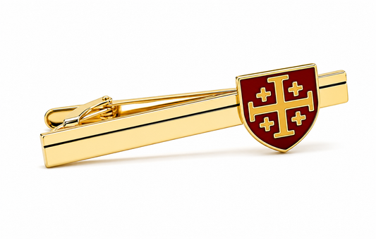 A gold tie bar featuring a shield-shaped red enamel emblem with a gold cross pattern, shown on a clean white background.