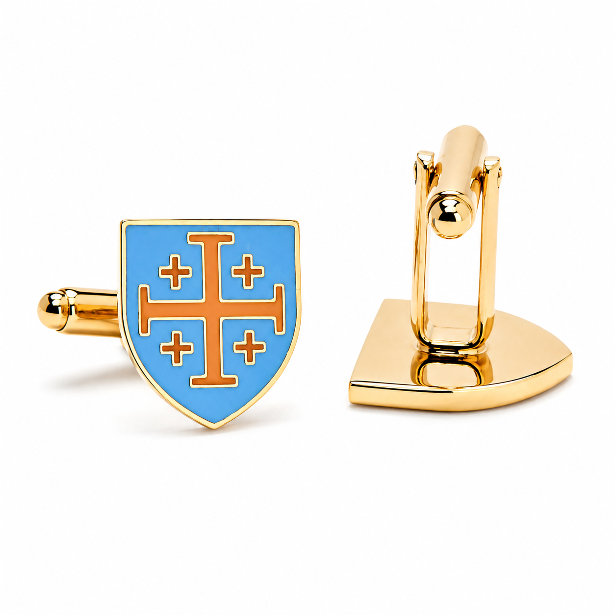 A pair of gold cufflinks on a white background, one showing the front shield face with a light blue enamel background and an orange double-cross motif, and the other showing the gold toggle back.