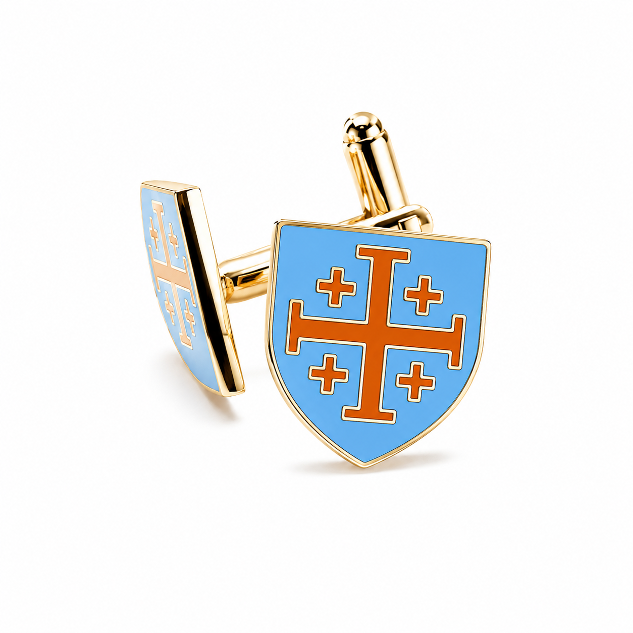 A pair of gold-tone cufflinks shaped like a shield with a light blue enamel face and an orange cross design, shown on a clean white background.