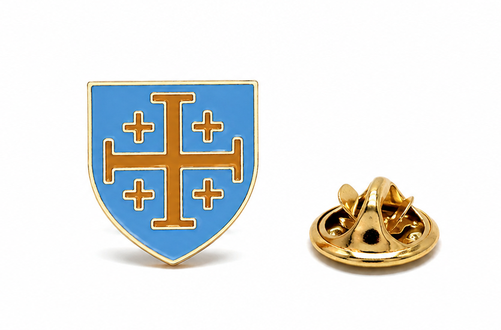A small shield-shaped enamel pin with a gold border, light blue background, and gold cross motif, shown alongside its gold metal clutch backing on a white background.