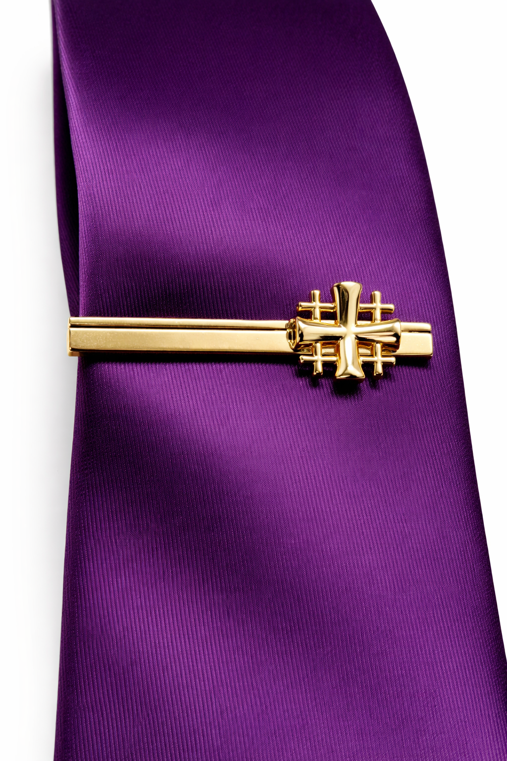 Gold Jerusalem Cross tie clip on a purple tie against a white background