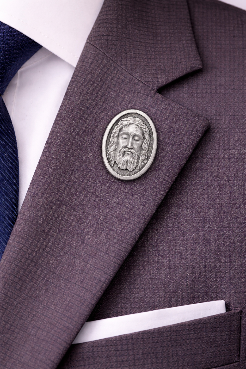 Close-up of a purple suit jacket with a decorative Holy Face of Jesus lapel pin made in Italy antique silver