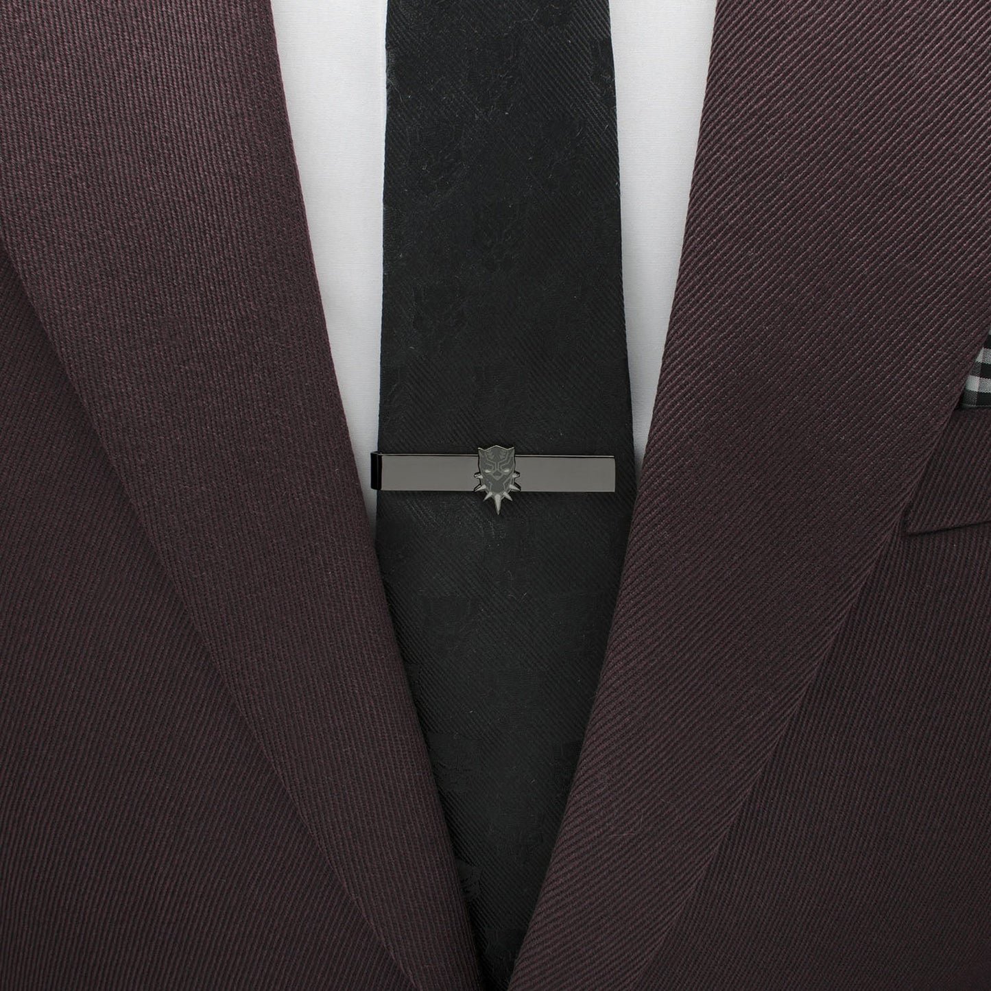 Brown suit jacket with a black tie and silver tie clip on a white background