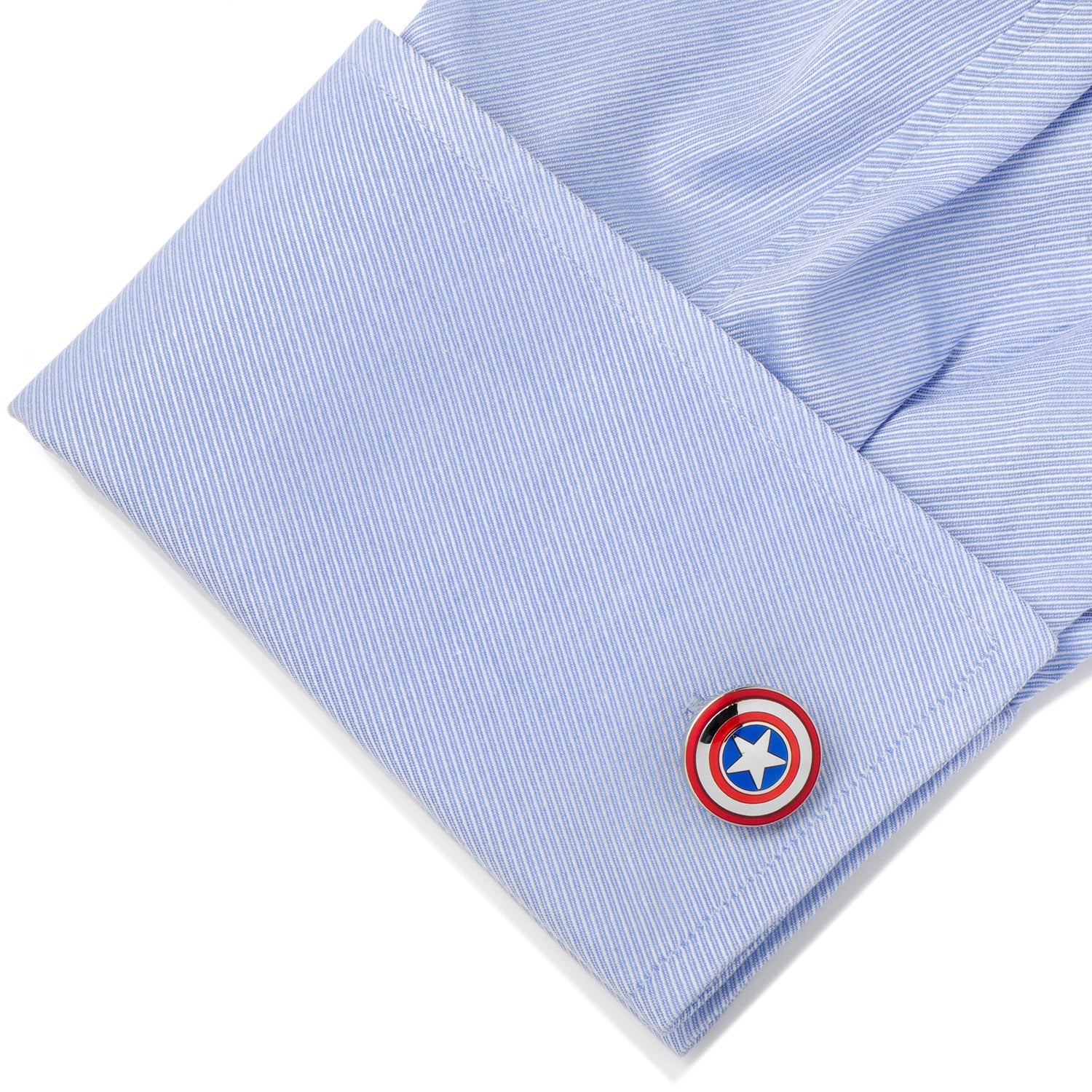 Cufflink with a shield design on a light blue striped shirt