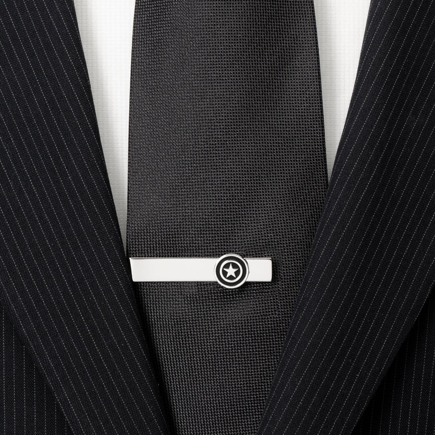 Black pinstripe suit with a silver tie clip featuring a star design.