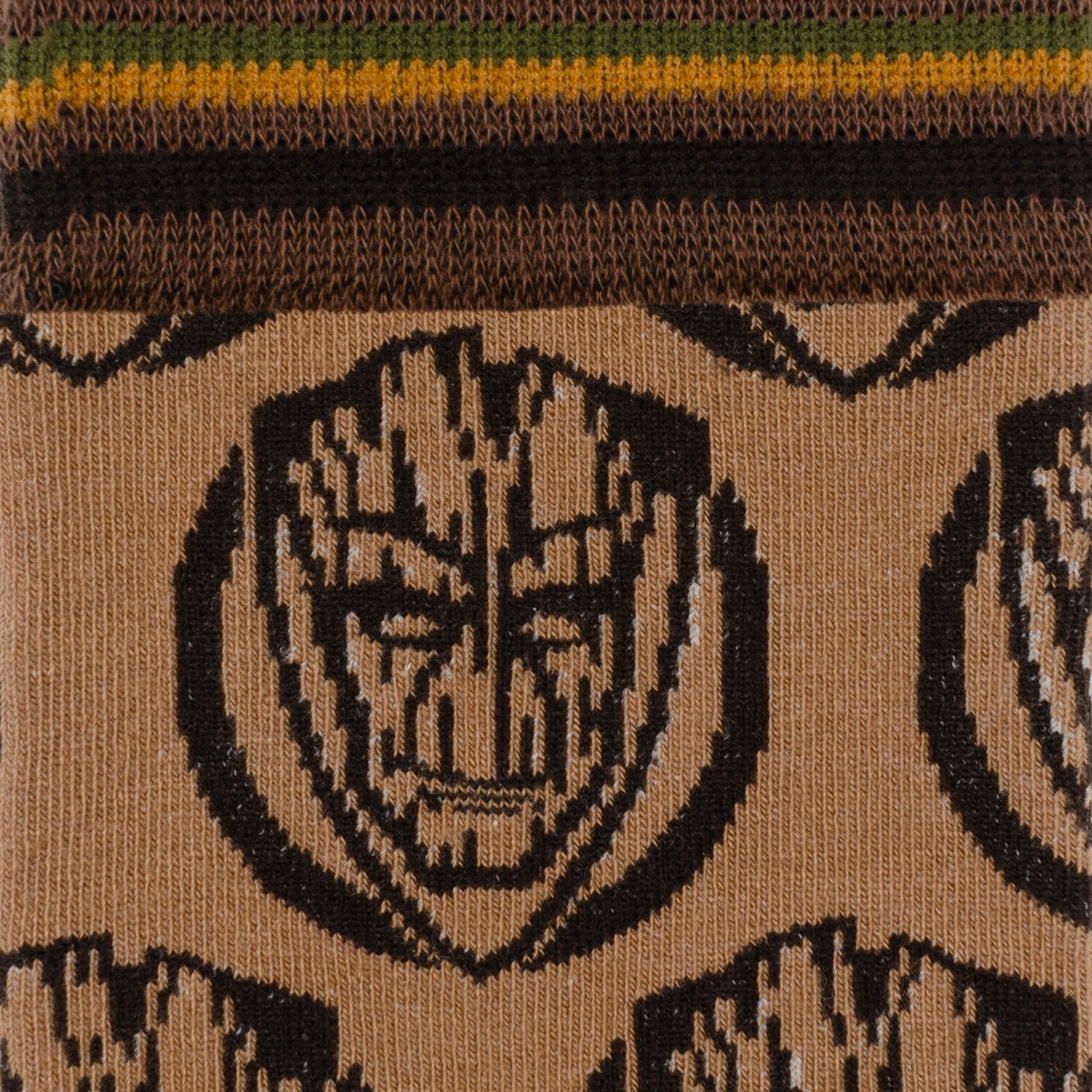 Close-up of a woven fabric with a tribal design on a brown background