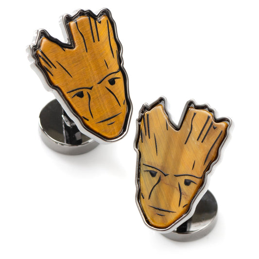 Two tree-shaped cufflinks with a face design on a white background