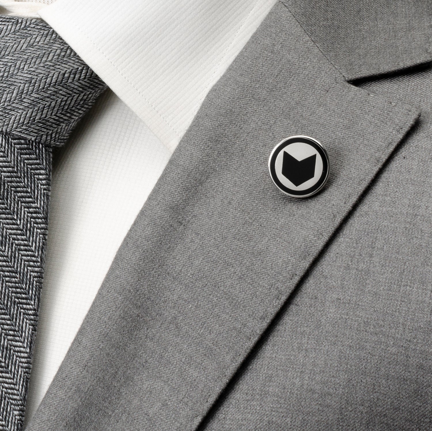 Gray suit jacket with a black and white logo pin on a white background Marvel Hawkeye Lapel Pin