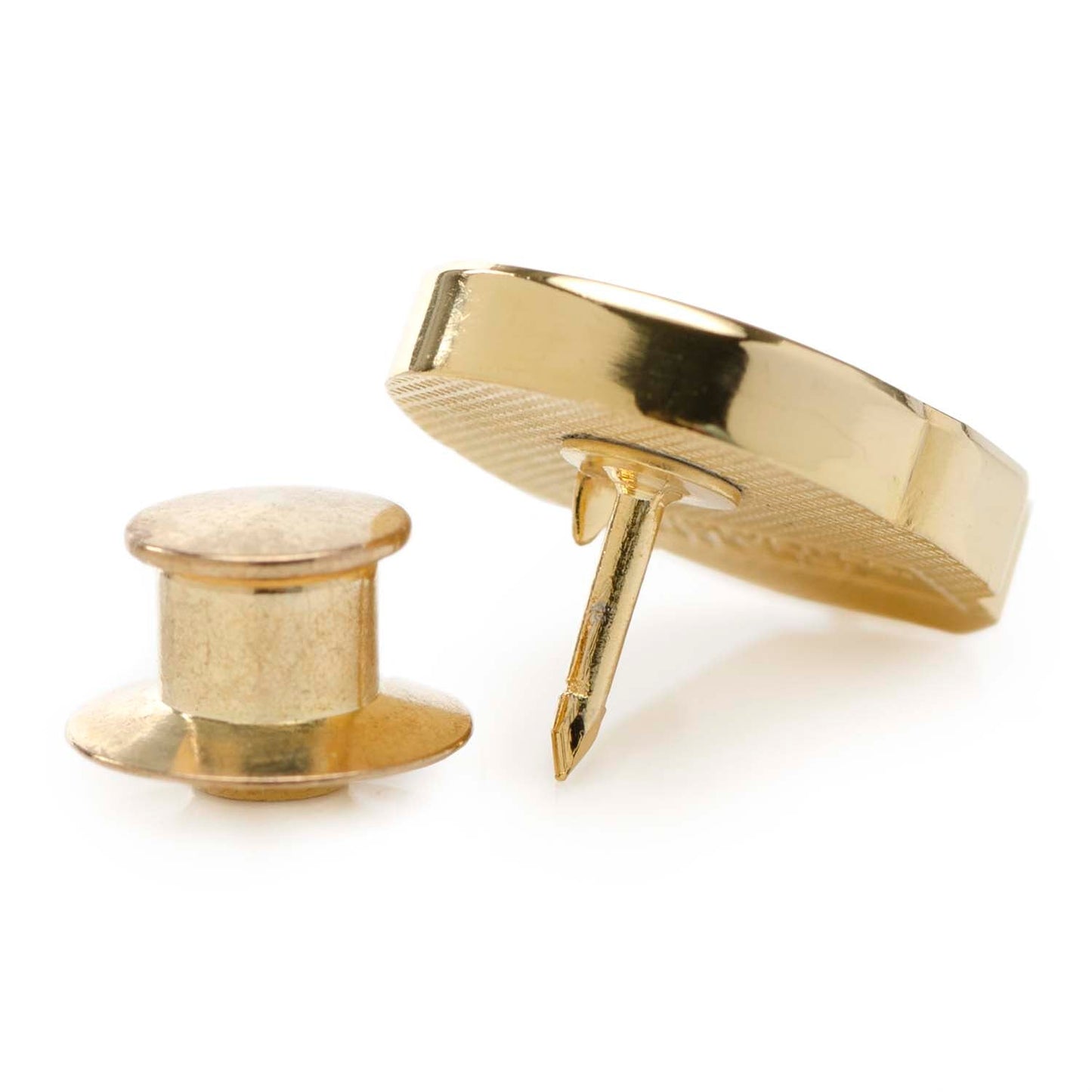 Gold-colored button and pin on a white background