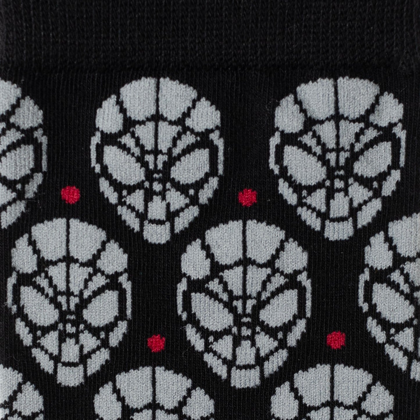 Patterned socks with black, white, and red design on a black background