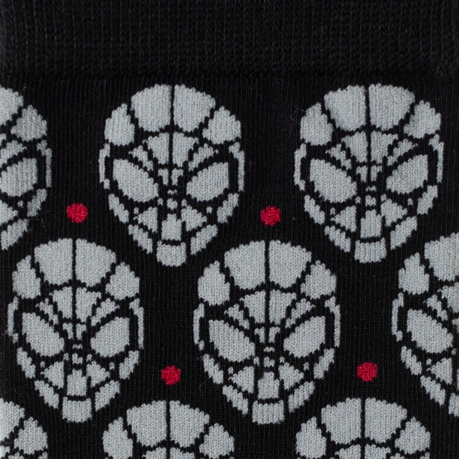 Patterned socks with black, white, and red design on a black background