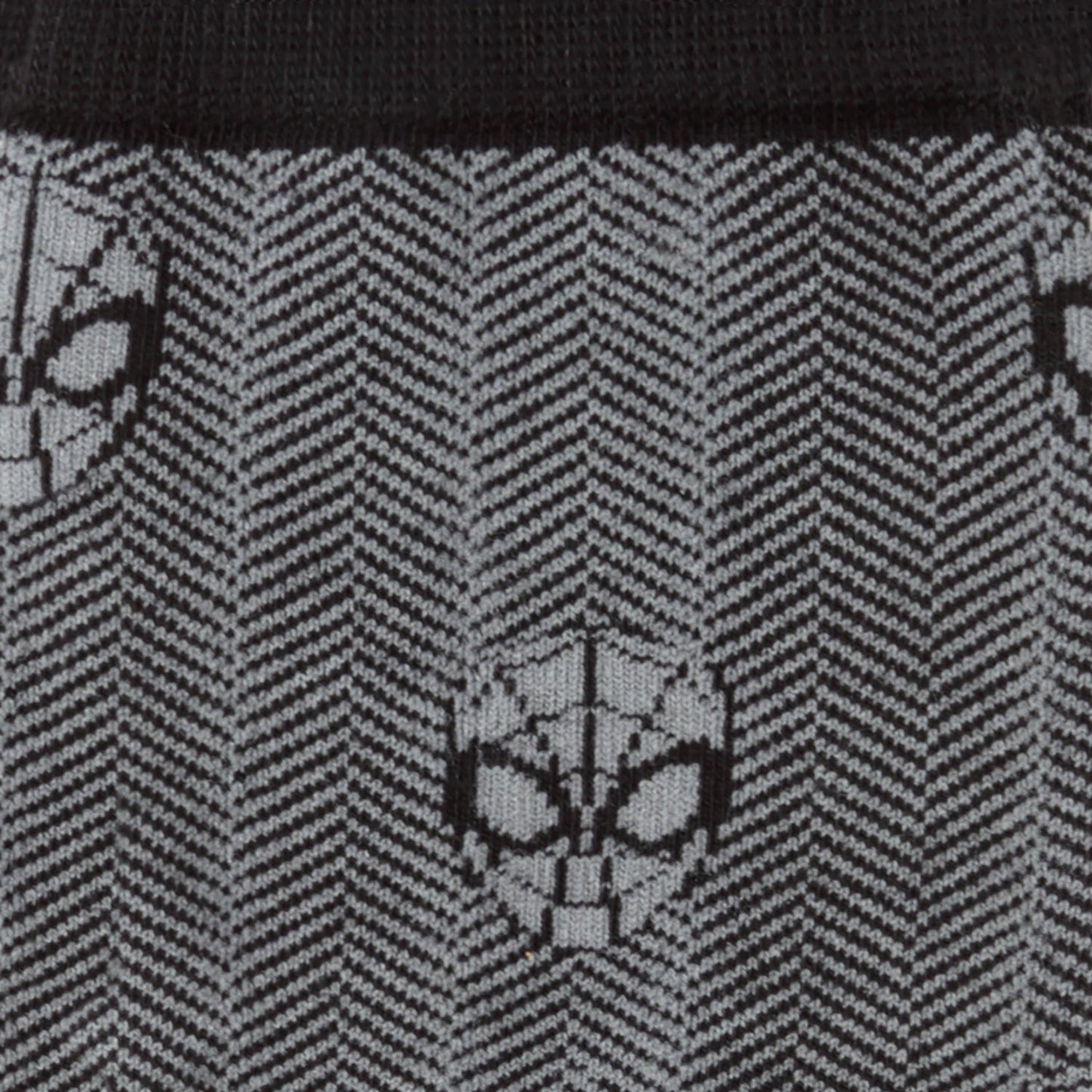 Close-up of a black and gray patterned fabric with spider-like designs.