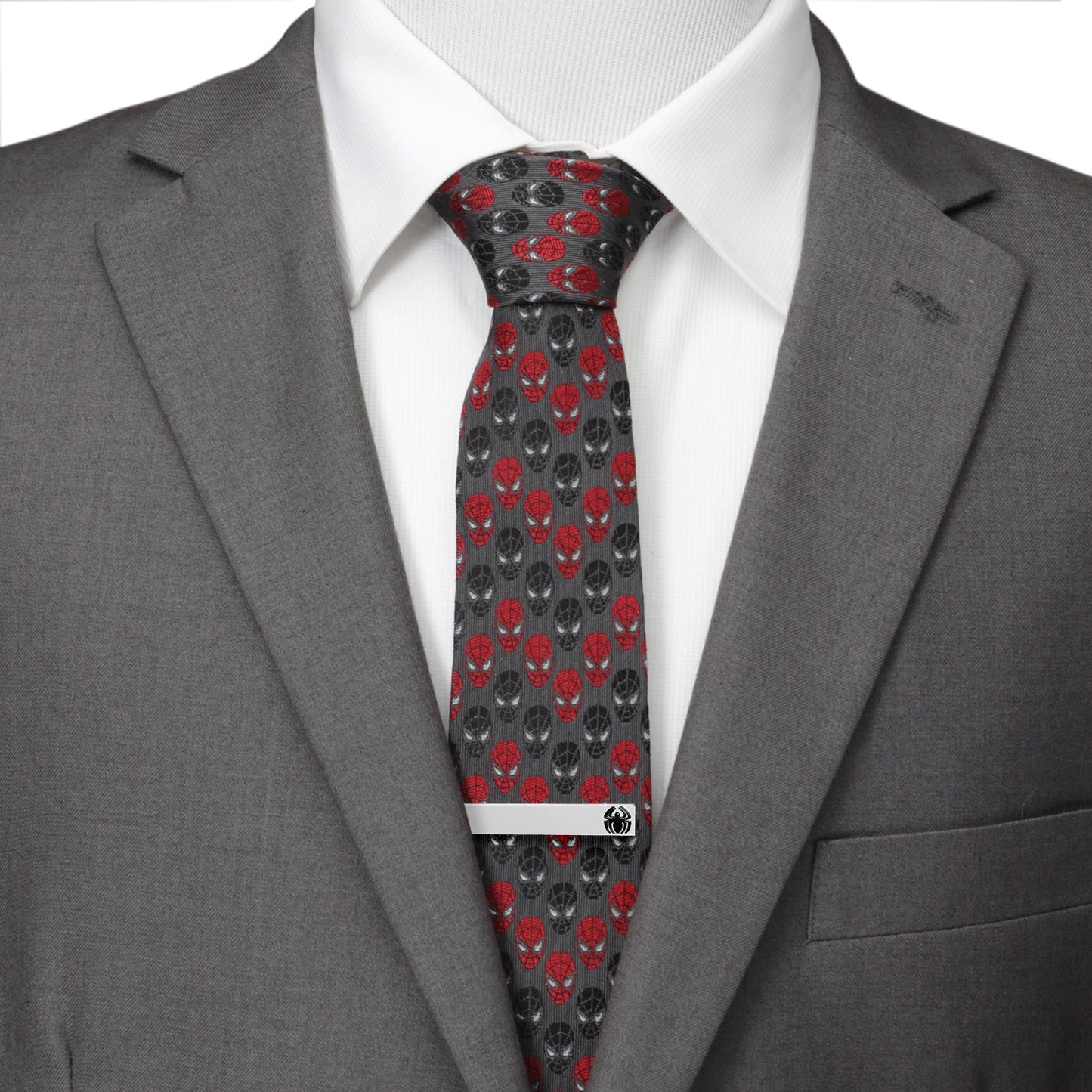Gray suit jacket with a white shirt and red and black patterned tie.