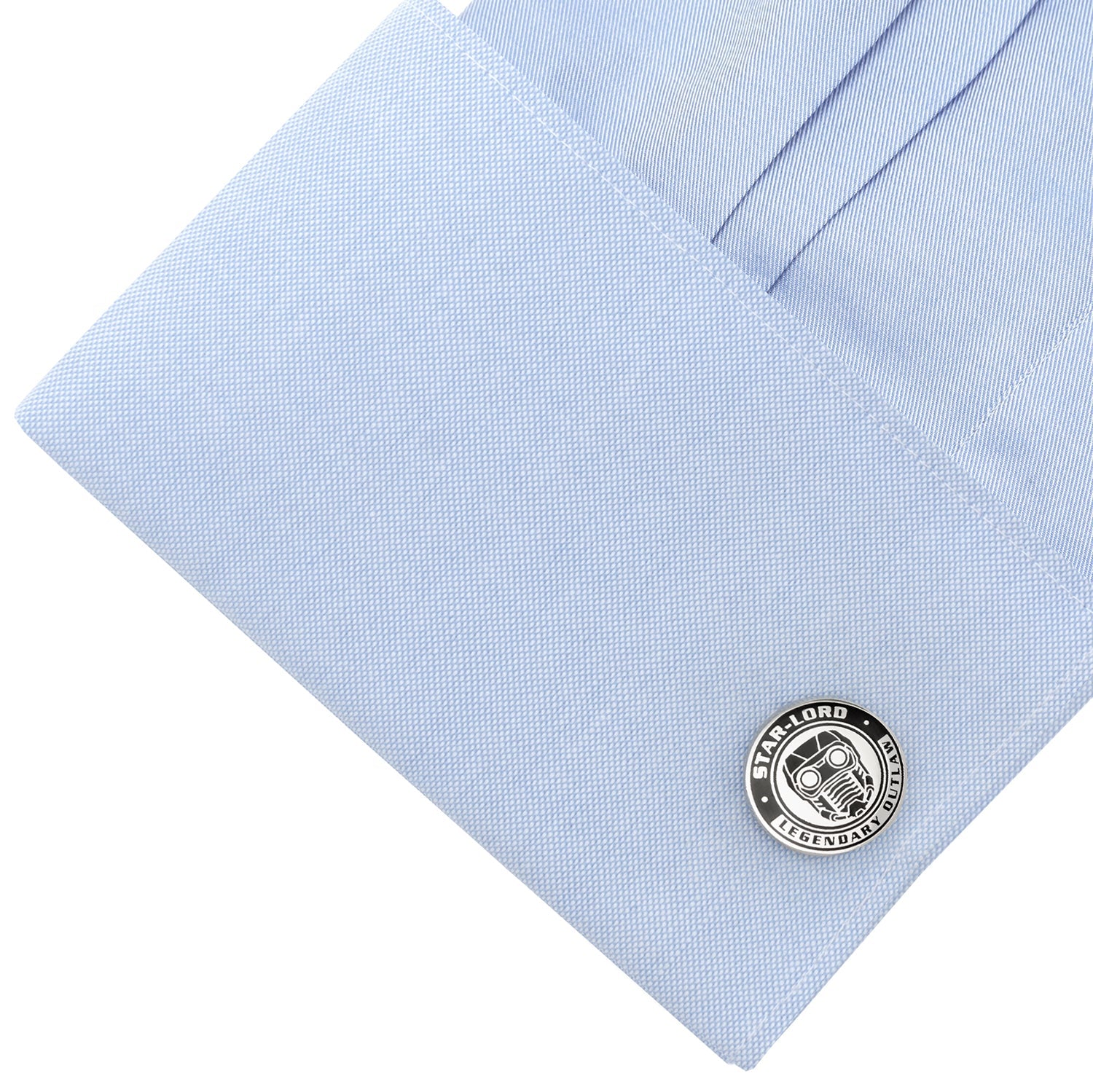Cufflink on a light blue dress shirt with visible brand logo.