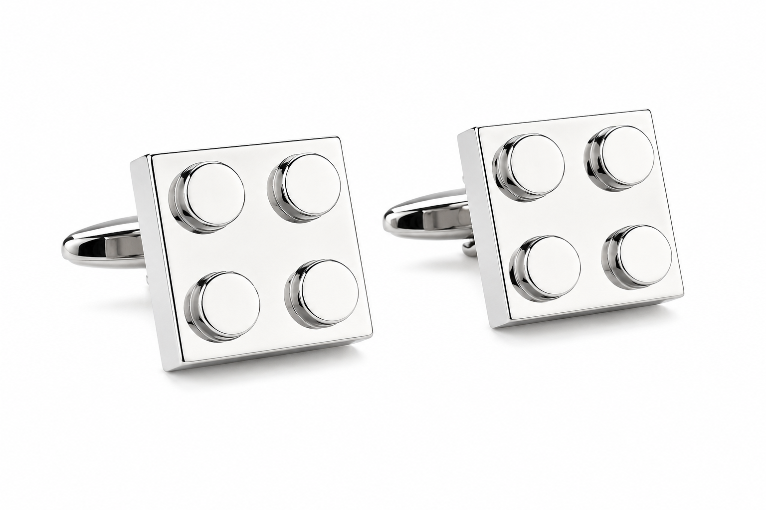 Silver cufflinks designed like building blocks on a white background